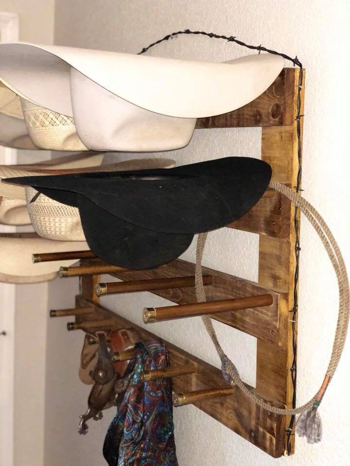 Wall-mounted hat organizer showing curved hat holders and small accessory hooks