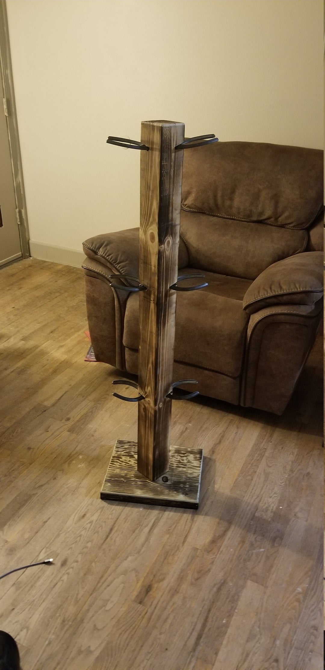 Rustic wooden cowboy boot floor stand with tall post, base, and side pegs.