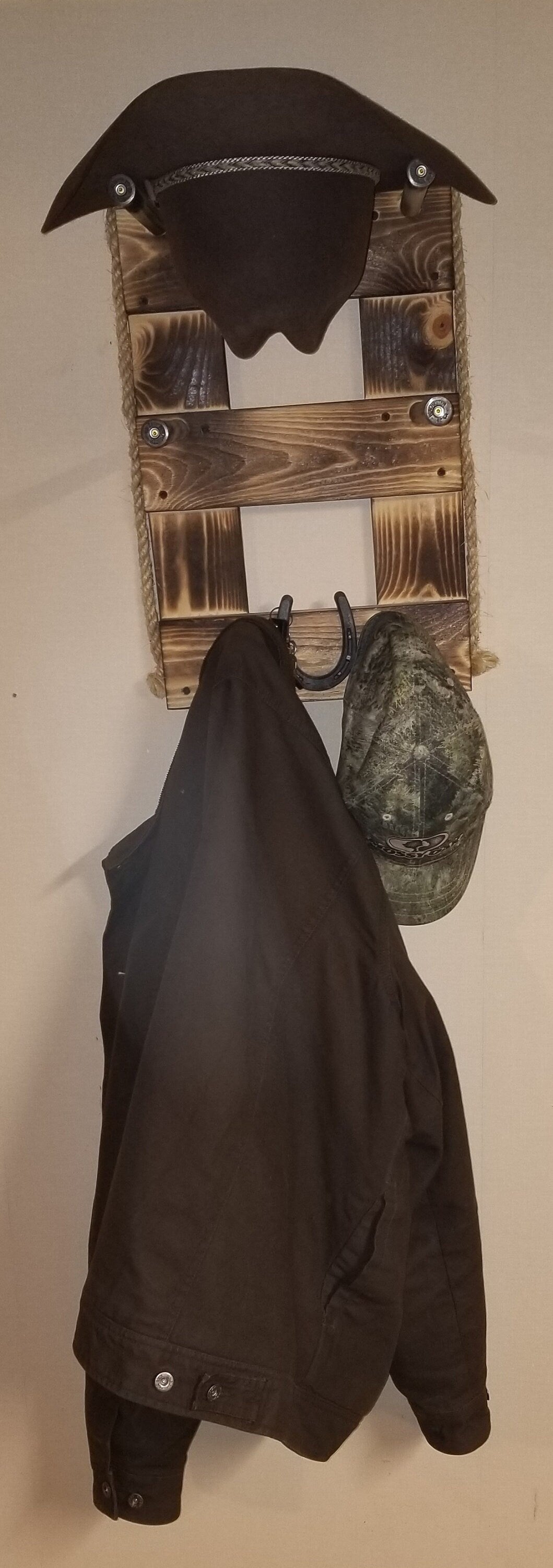 Vertical wall-hanging organizer with two hat slots and multiple hooks in brown wood