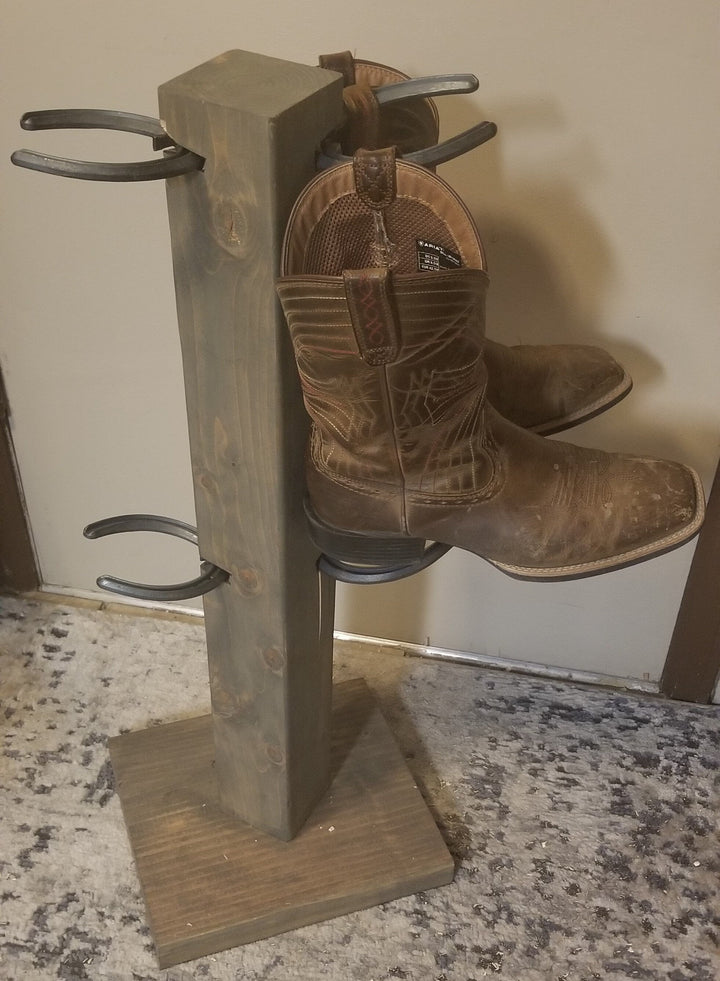 Wood boot floor stand holding two cowboy boots with metal side loops and square base