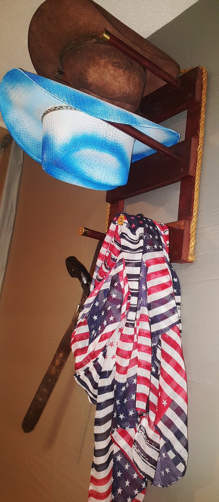 Vertical wall-hanging organizer with two hat slots, hooks, and three visible items
