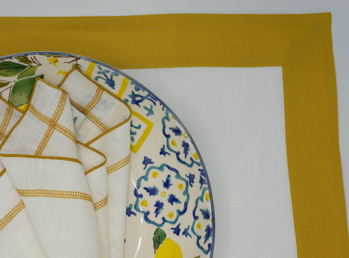 Linen placemat corner with mustard border and white panel, close-up