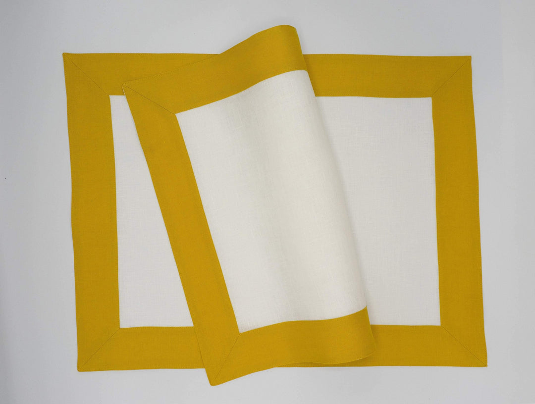 Set of linen placemats, stacked with mustard borders and white centers