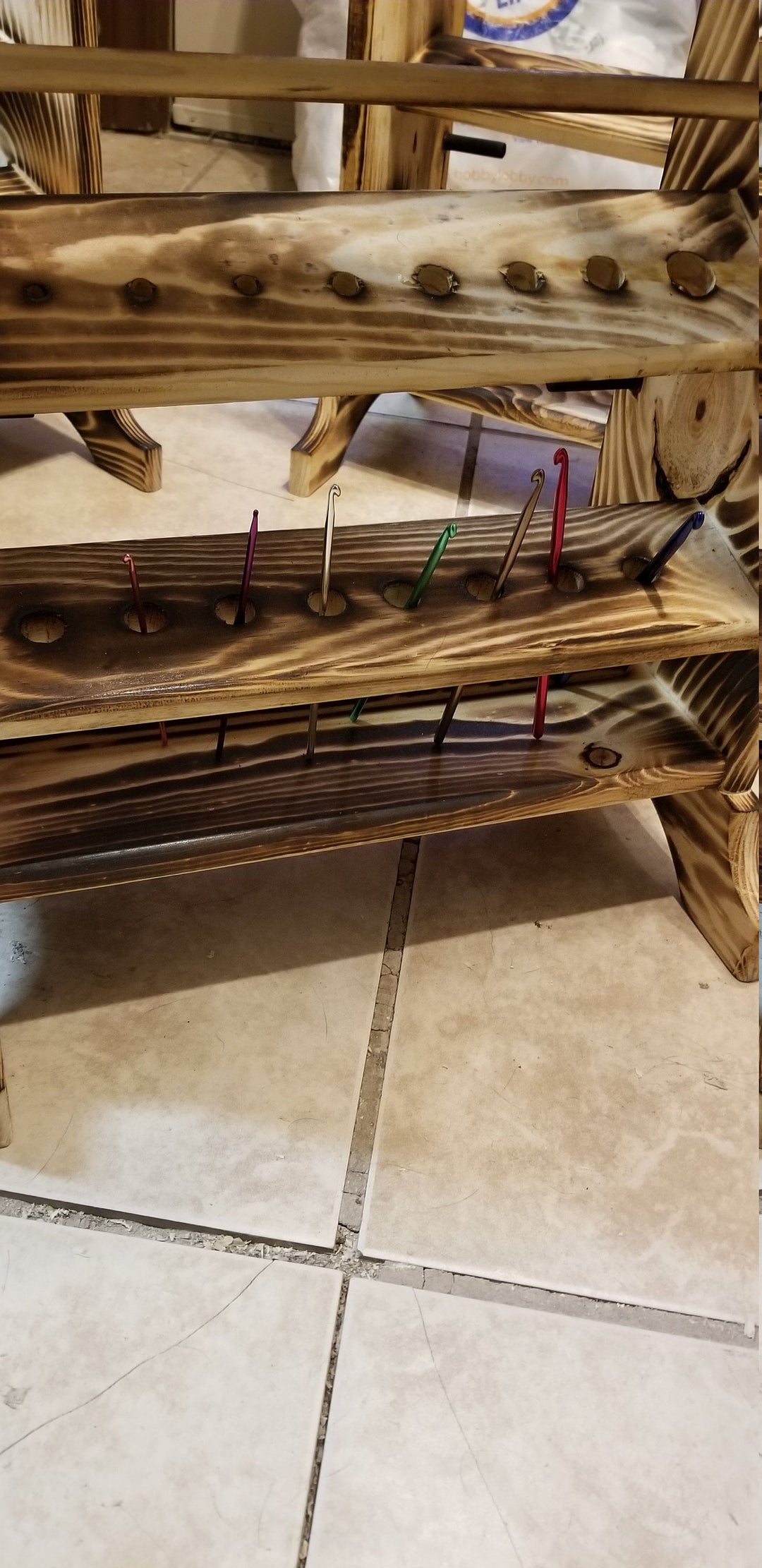 Close-up of wooden yarn rack shelves with front peg hooks and bar supports