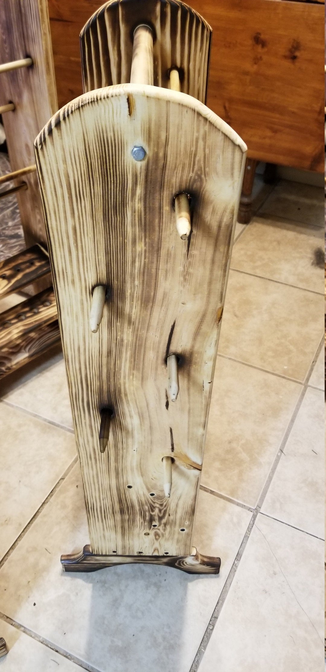 Upright wooden yarn holder with curved top and multiple yarn pegs