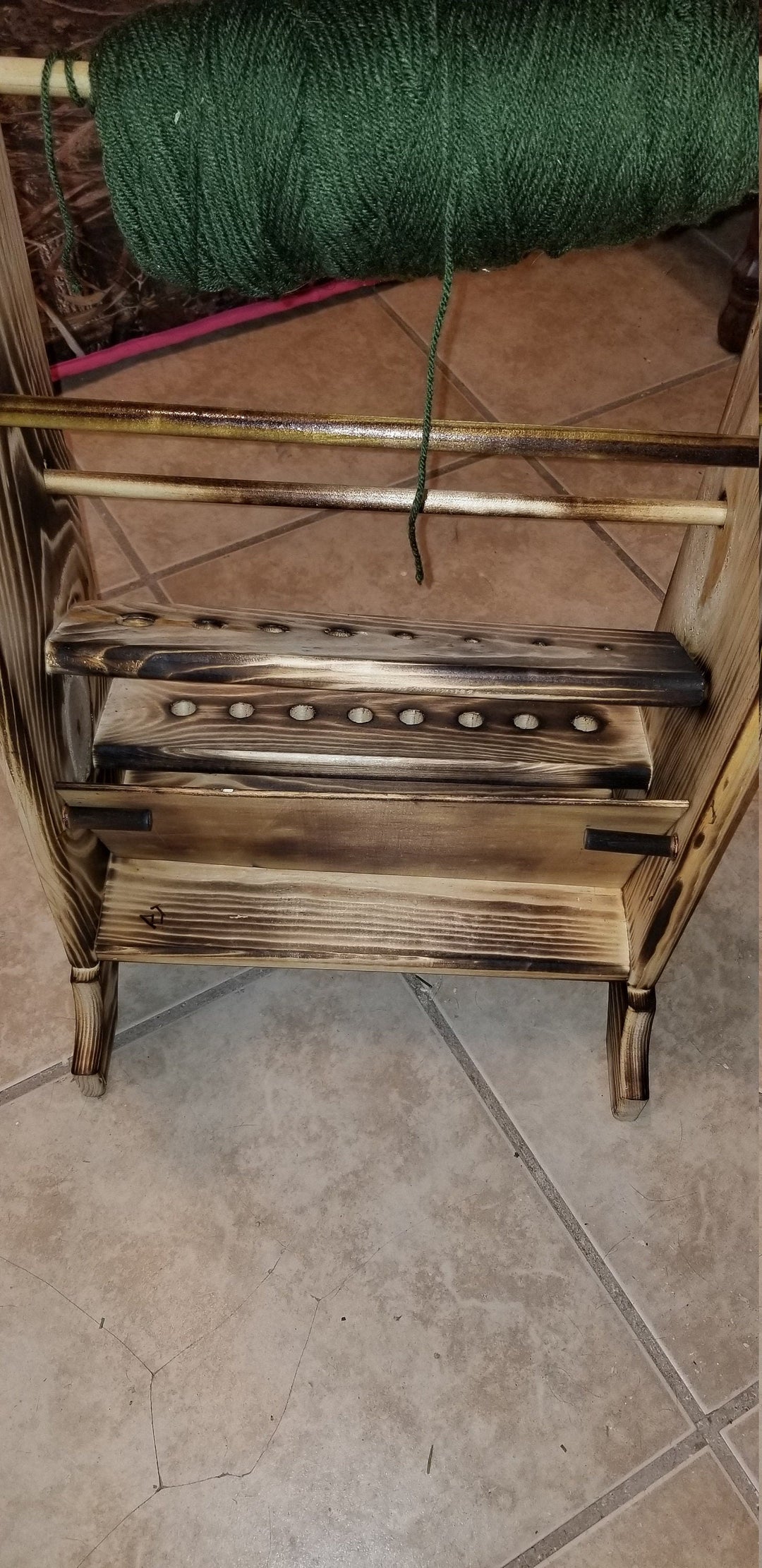 Wooden yarn holder with top green yarn skein and peg bars