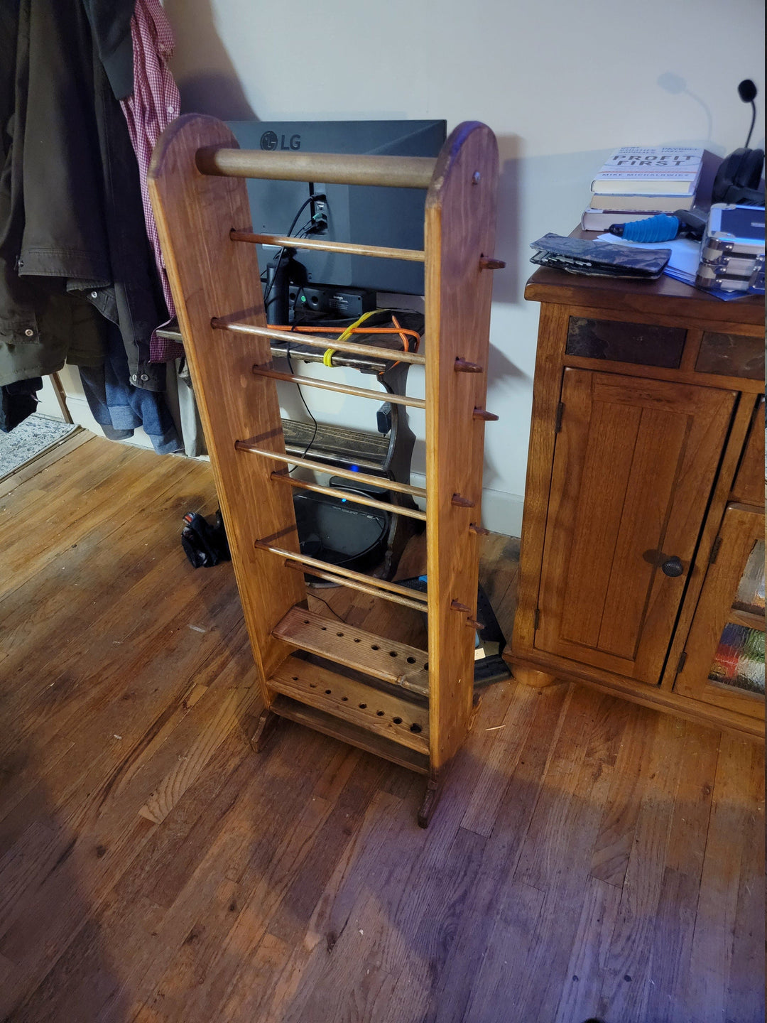 Tall wooden yarn holder with multiple horizontal rails and peg shelf rows