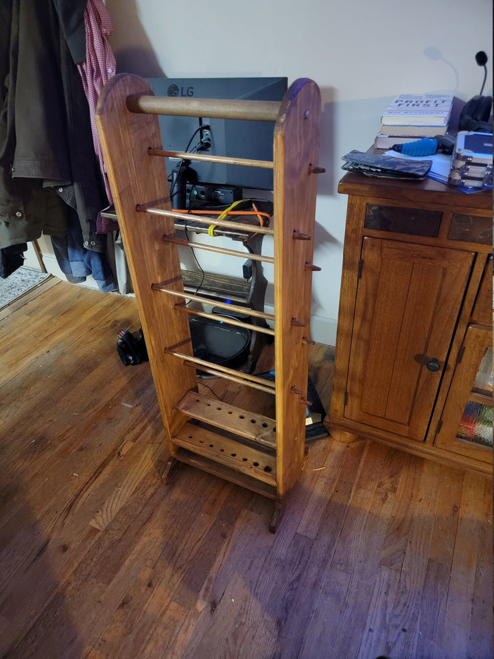 Tall wooden yarn holder with multiple horizontal rails and peg shelf rows