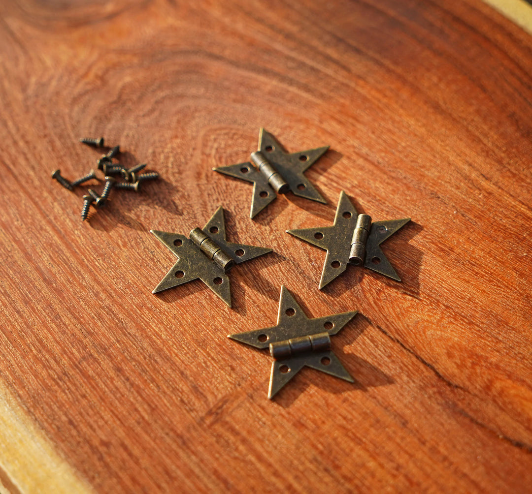 Set of bronze star hinges laid on a wooden tabletop