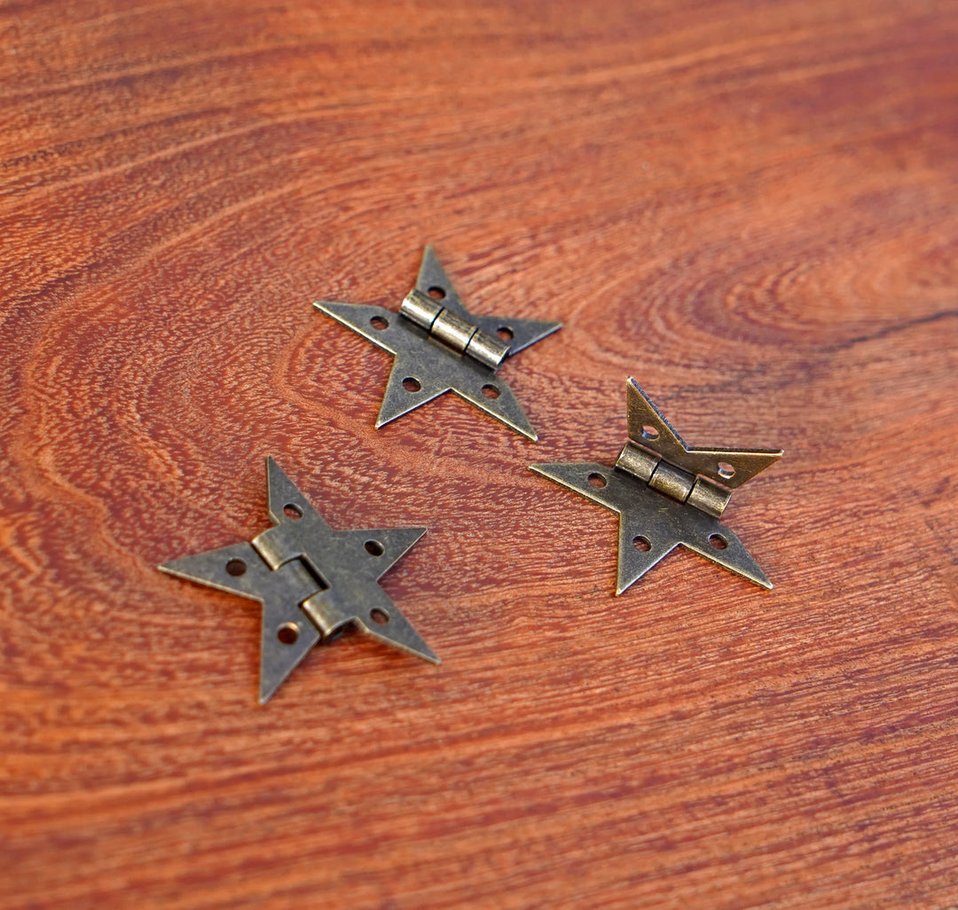 Bronze finish star hinges with back plates and central hinge barrels on wood