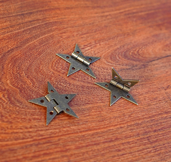 Bronze finish star hinges with back plates and central hinge barrels on wood
