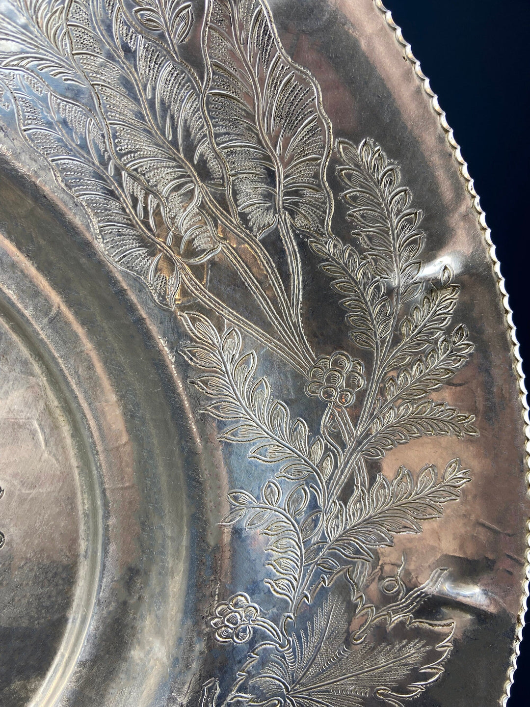 Silver metal serving bowl with scalloped edge and engraved floral and leaf pattern