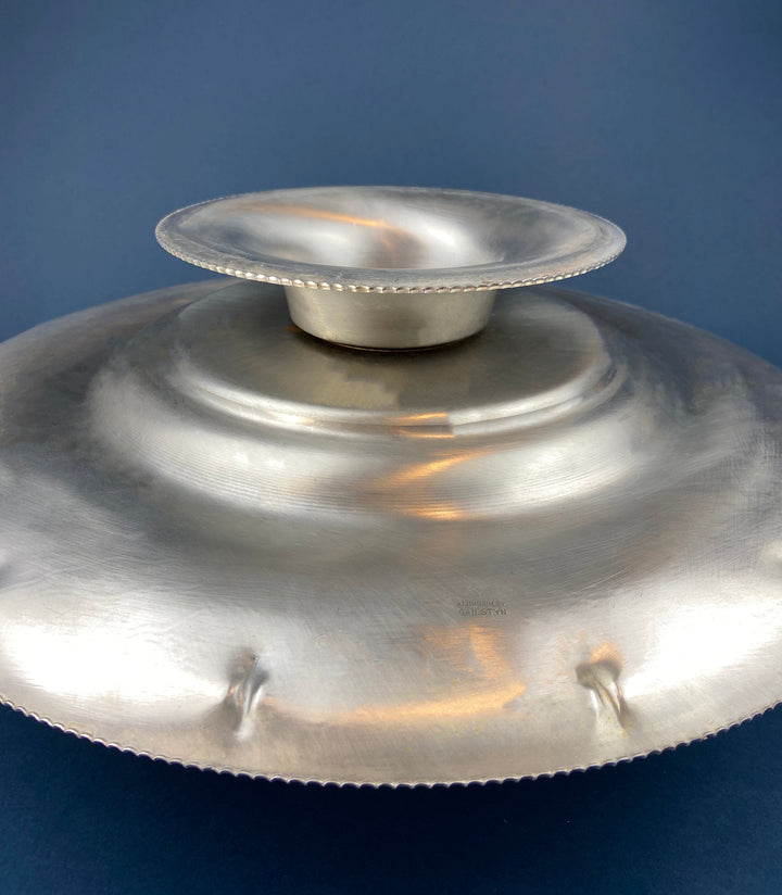 Silver metal footed serving bowl with rounded pedestal base and scalloped rim