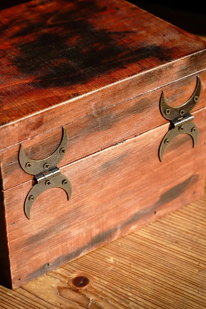Bronze-finished steel crescent moon hinges mounted on a wooden chest panel