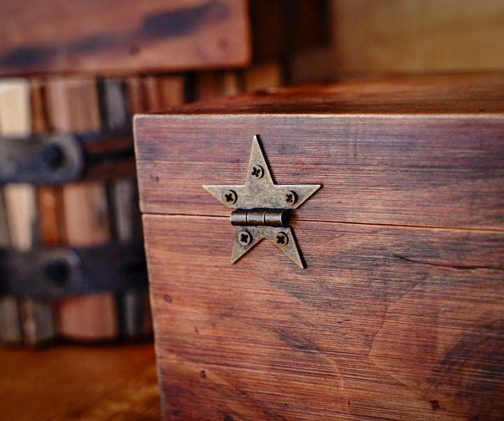 Bronze star hinge with screws mounted on a wooden crate panel