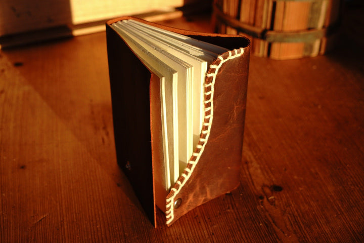 Brown leather journal angled view with white blanket edge stitching
