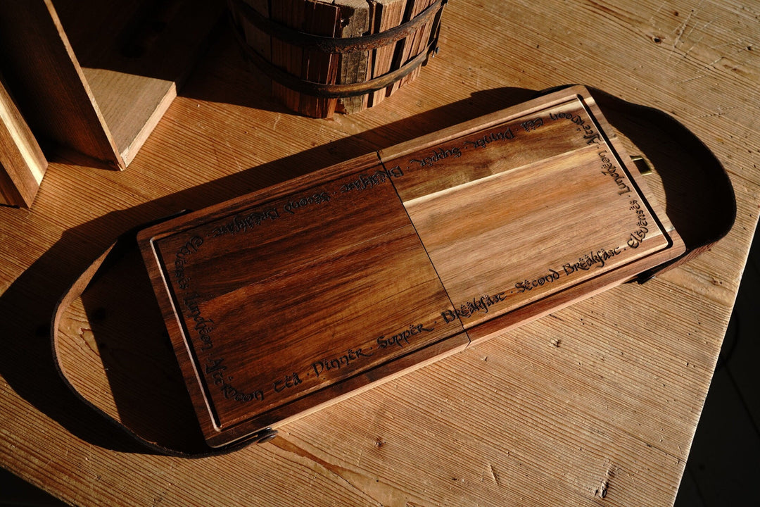 Folding acacia cutting board with internal utensil storage compartments in open position