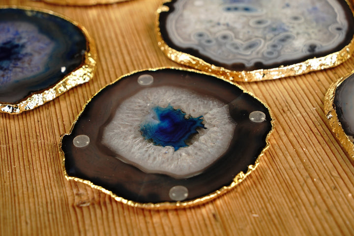 Round blue agate coaster close-up with gold rim and small clear rubber feet on top
