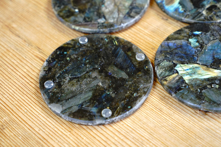 Round labradorite coaster with silver studs on edge, blue-gray iridescence