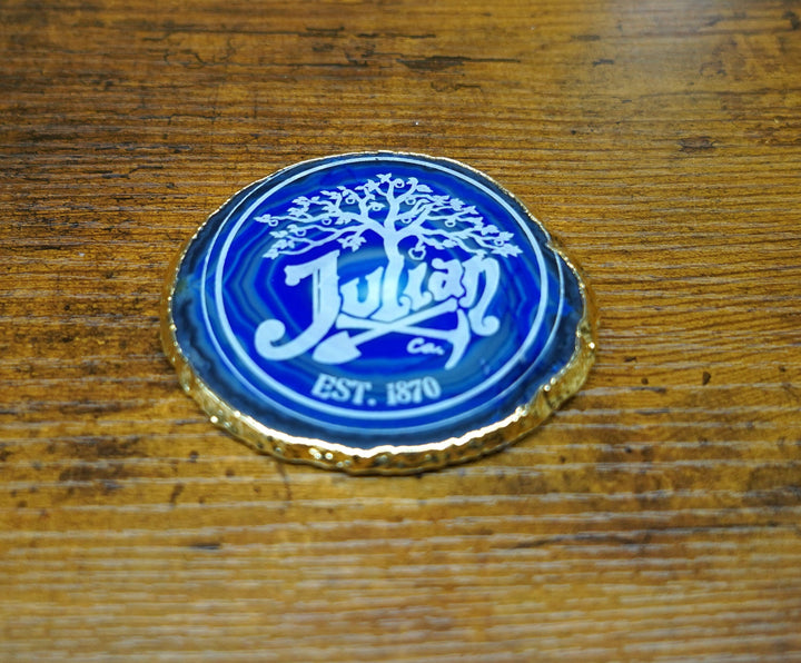 Blue logo coaster with gold rim, reading “Julien” and “EST. 1870”