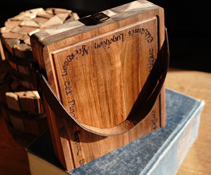 Acacia wood folding cutting board with leather handle, hinge seam, and engraved markings
