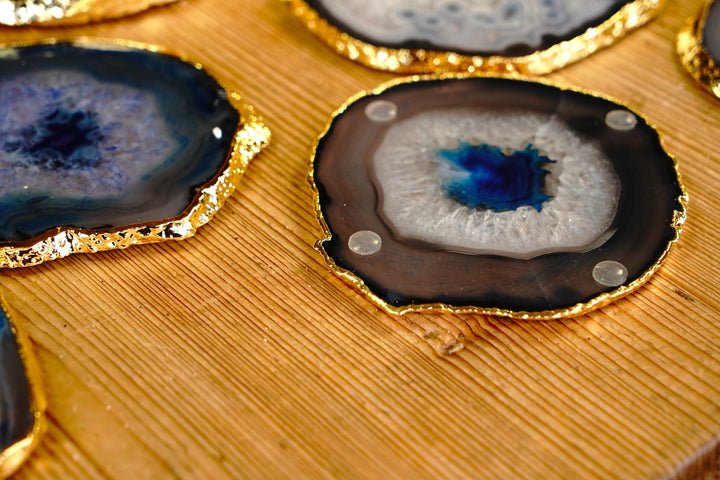 Close-up of a round blue agate coaster with gold rim and small clear rubber feet