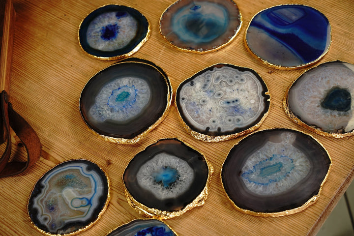 Round blue agate coasters with gold rims, showing varied blue and gray stone veining