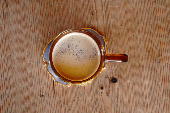 Amber double-walled glass mug top view with frothy beverage