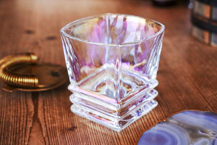 Iridescent lowball whiskey glass with stacked ridges, front view on wooden table