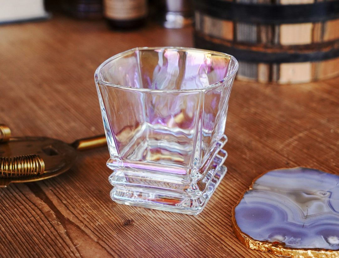 Iridescent lowball whiskey glass with purple-gold sheen and ribbed lower section