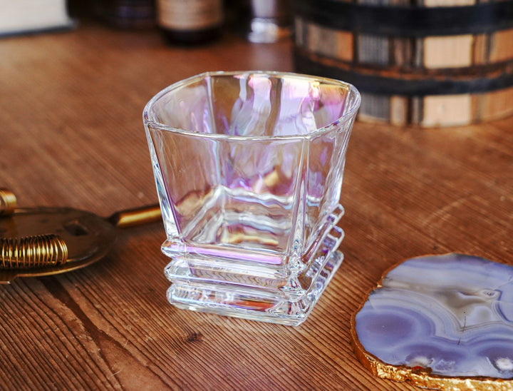 Iridescent lowball whiskey glass with purple-gold sheen and ribbed lower section