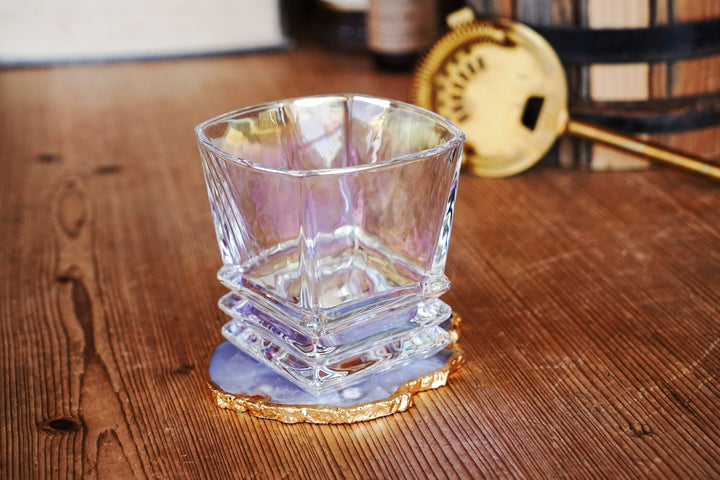 Iridescent lowball whiskey glass with faceted sides and stacked band base, side angle
