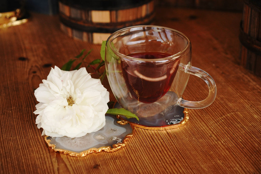 Clear double-walled glass mug with red tea and heart-shaped insert, side handle