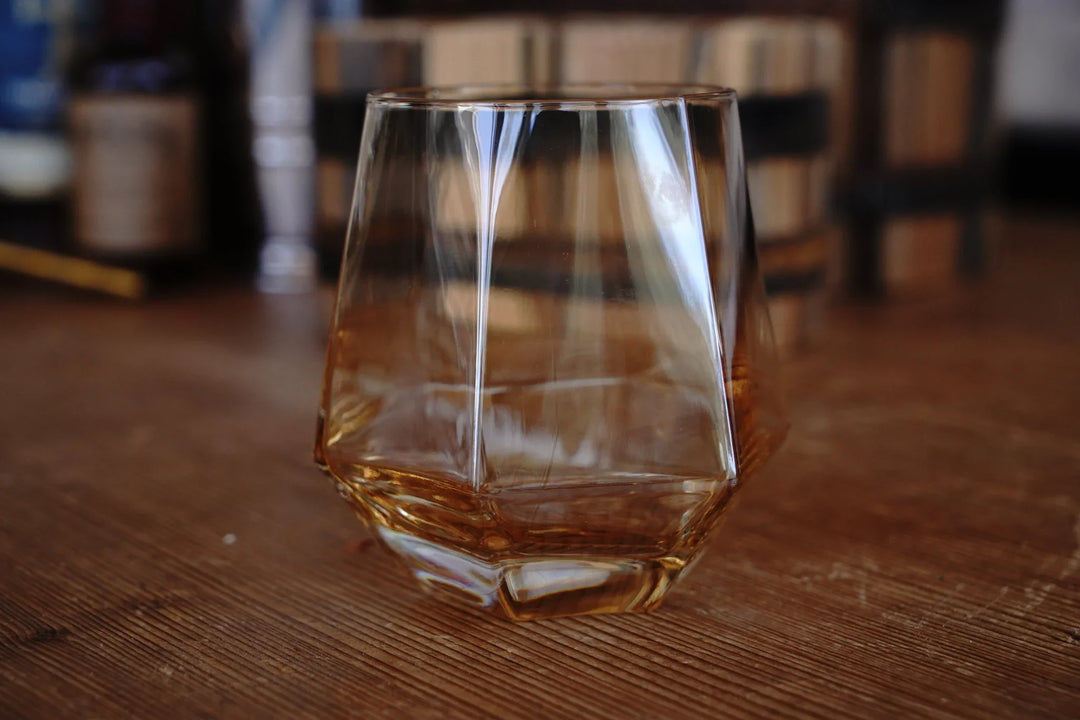 Amber diamond bourbon glass with rounded base and faceted side panels