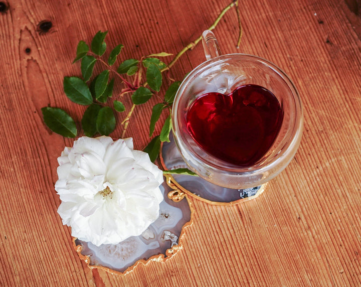 Clear double-walled glass mug with red tea and heart-shaped insert