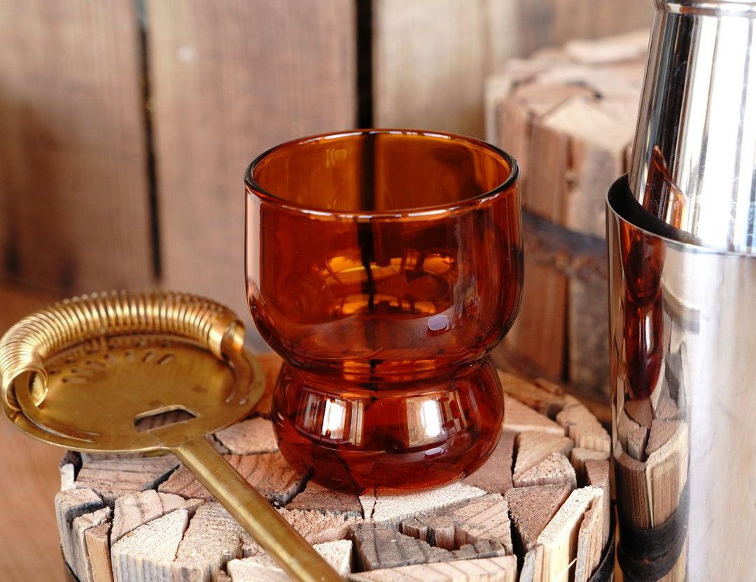 Amber orange bubble juice glass on a stone block surface