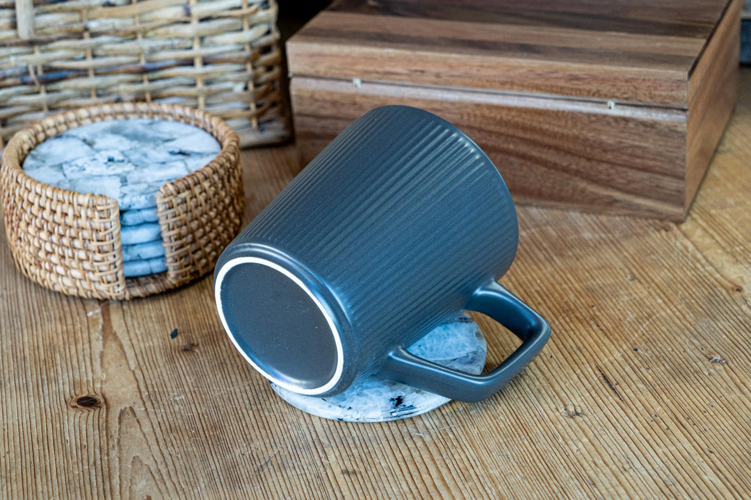 Blue ribbed ceramic mug tilted on its side, showing interior