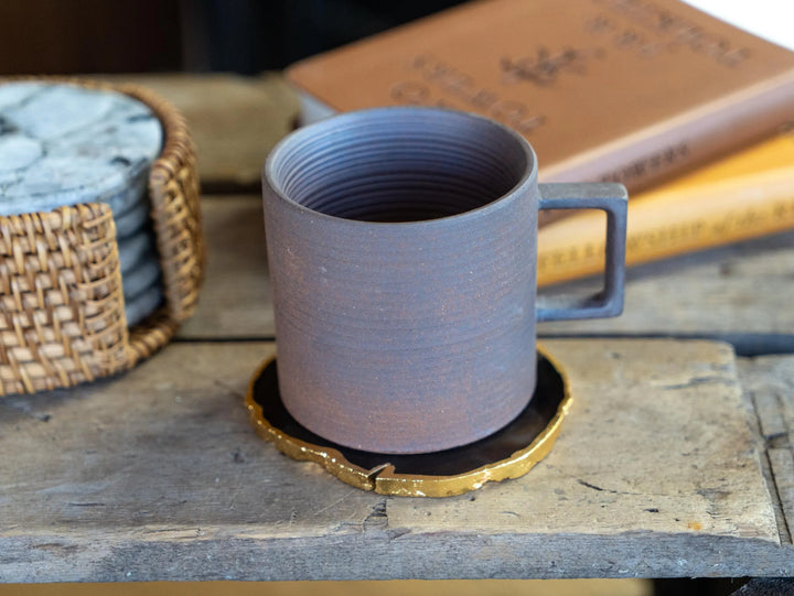 Stoneware espresso mug with side handle on gold-edged ceramic tray