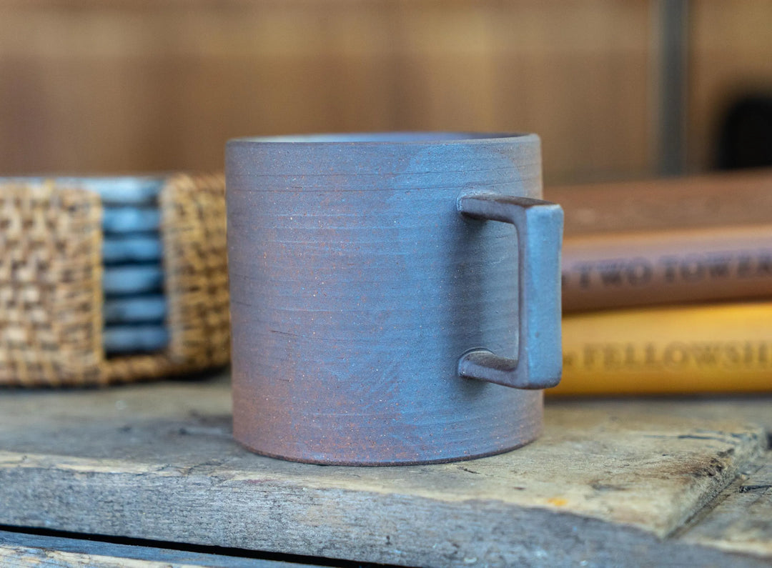 Stoneware espresso mug, light purple-gray, angled view showing square side handle