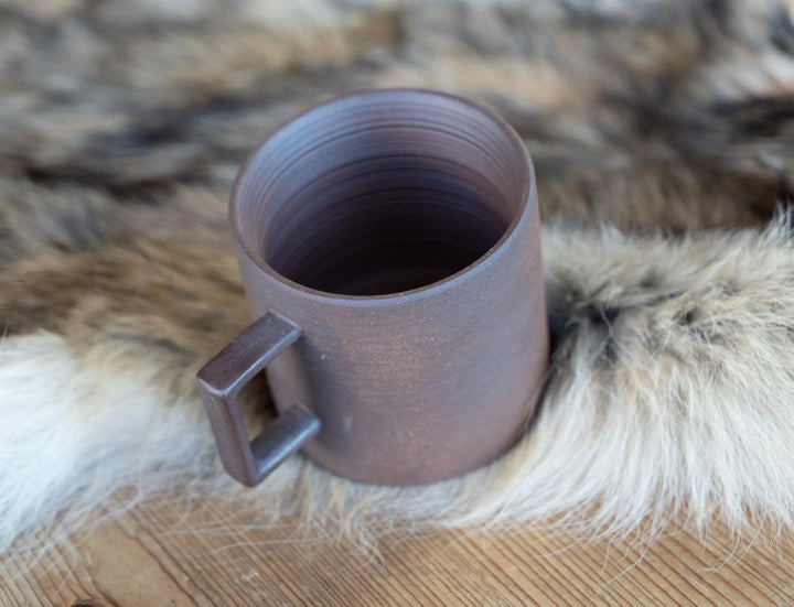Stoneware espresso mug, light purple-gray, open top and side handle on faux-fur