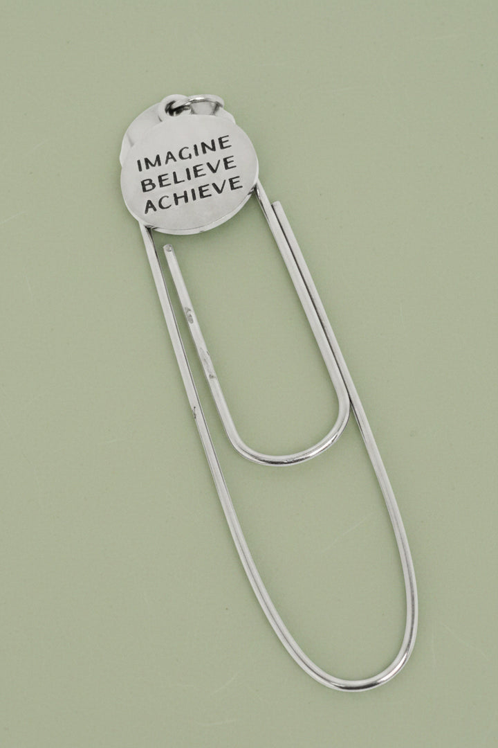 Silver paperclip bookmark with round engraved charm: 'IMAGINE BELIEVE ACHIEVE'