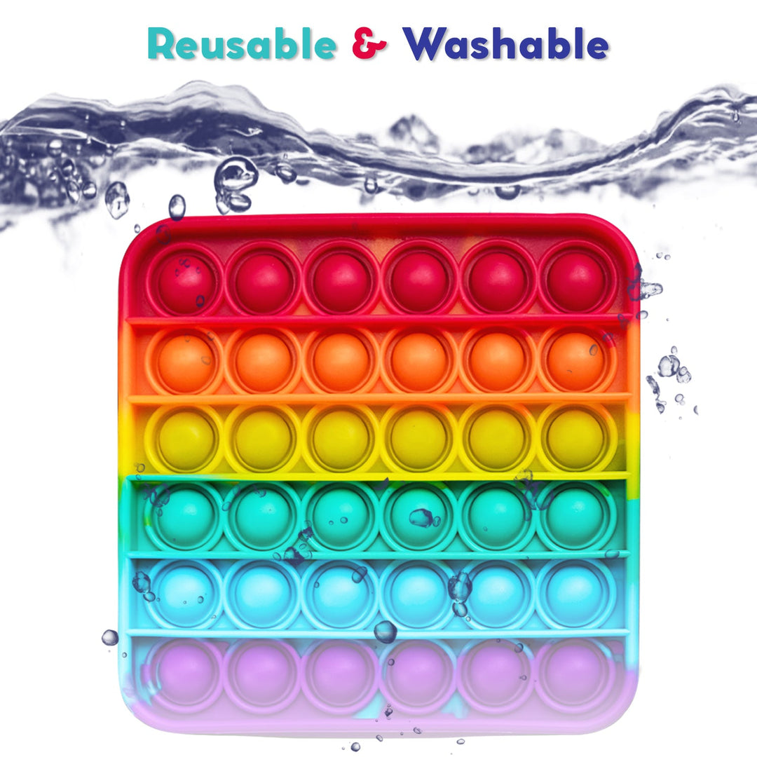 Rainbow silicone pop fidget mat with circular bubble rows, shown with water splashes