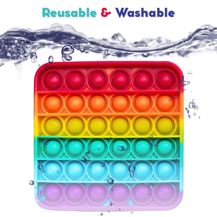 Rainbow silicone pop fidget mat with circular bubble rows, shown with water splashes