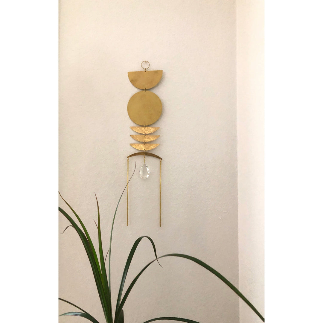 Gold sun catcher wall hanging with stacked crescent discs and crystal teardrop