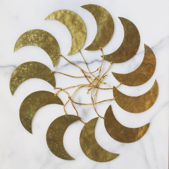 Gold crescent-moon ornament with layered moon cutouts and hanging gold bead chains