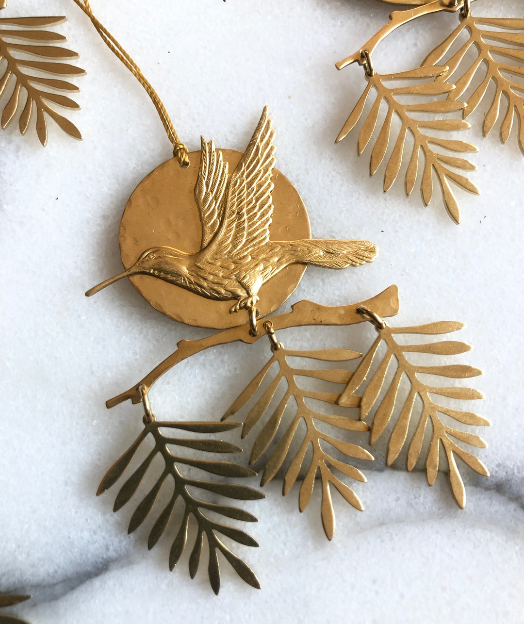 Gold mini hanging ornament with round disc, bird-wing shape, and leaf charms