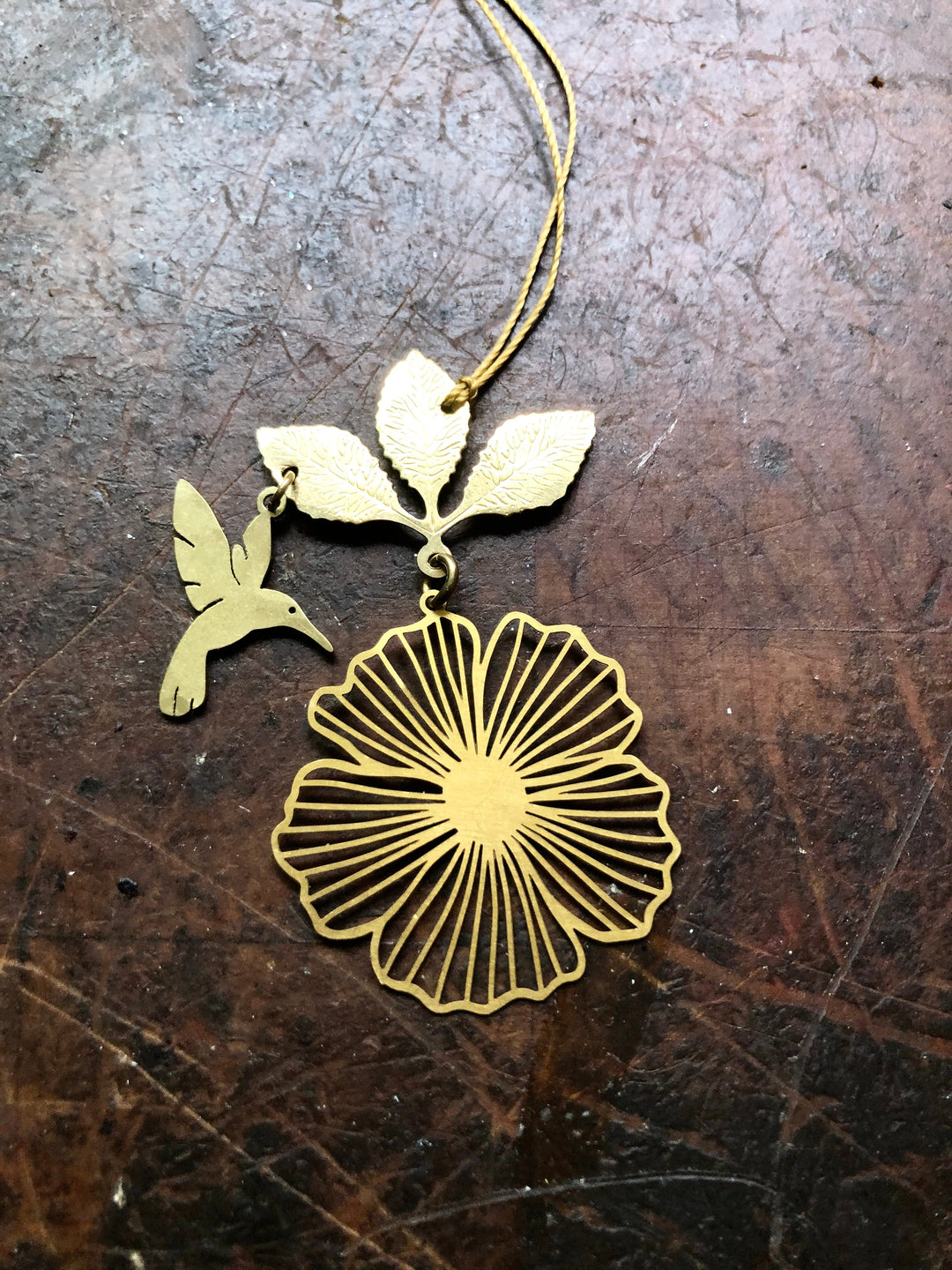 Gold hibiscus flower ornament with hummingbird and leaf charm, hanging string loop