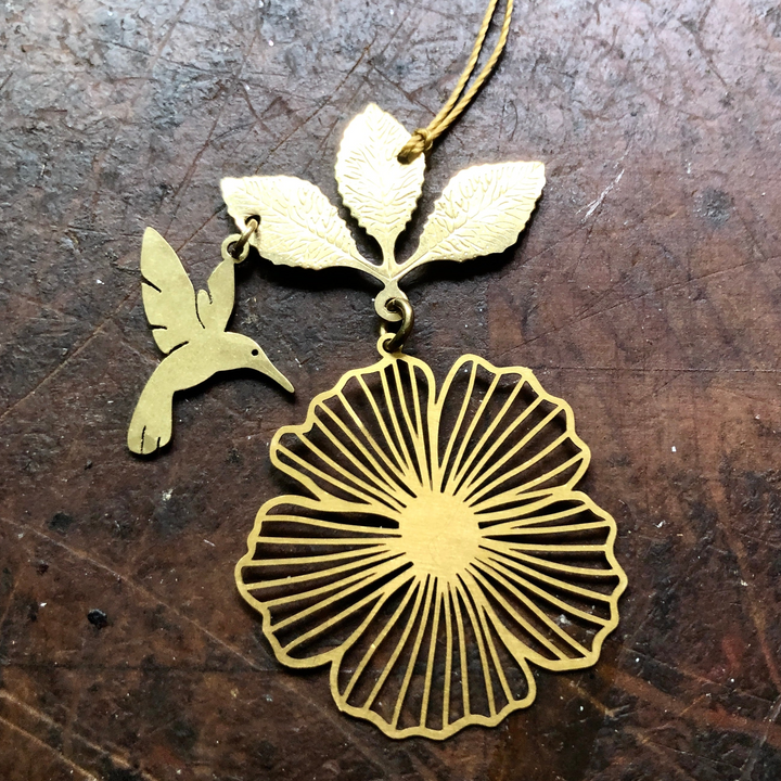 Gold hummingbird and hibiscus flower ornament with hanging loop, bird and petals details