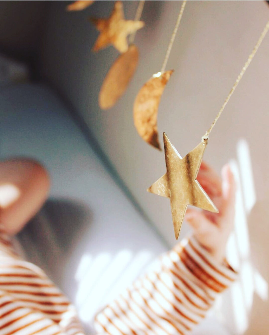 Gold hammered star charm on a thin brass chain, with crescent and round tags