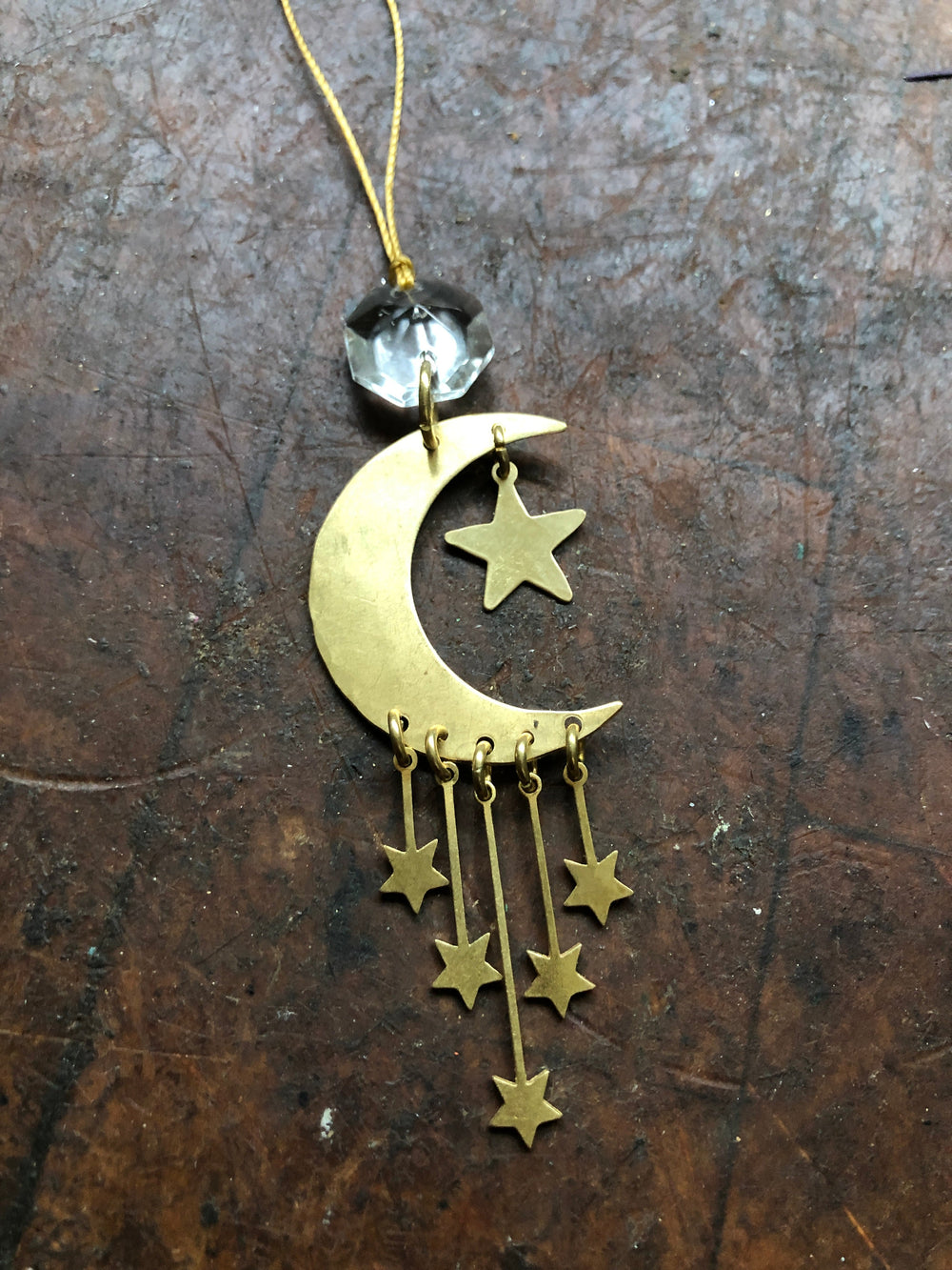 Gold crescent moon ornament with hanging star charms and clear glass crystal top